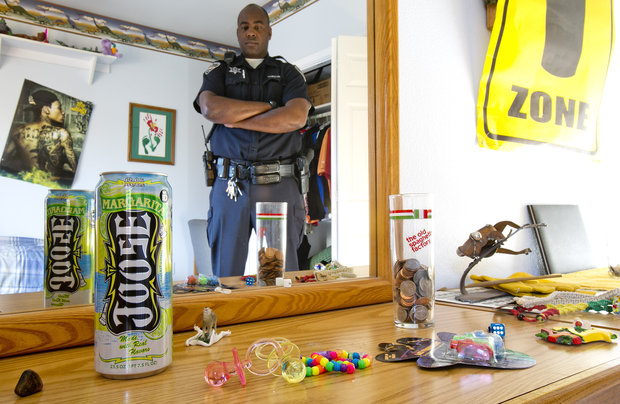 Jermaine Galloway's reflection in a mirror on a dresser top filled with drug paraphernalia