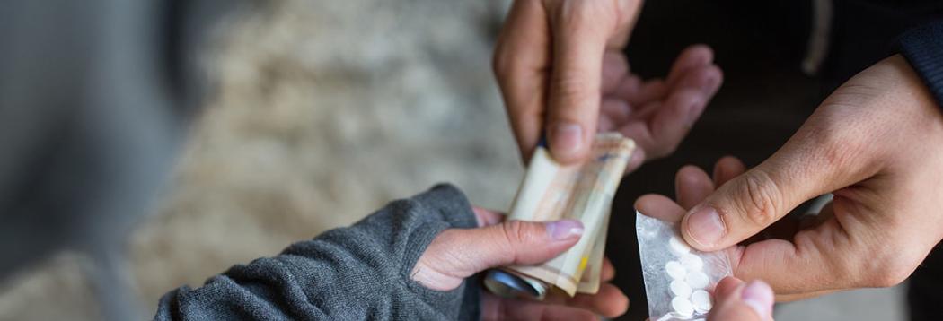 Drug dealer exchanging pills for cash